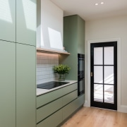 Green cabinetry works well with wood look flooring. 