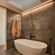 A large skylight above the bathtub floods the 