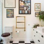 Brass fittings were chosen to complement the dramatic bathroom, floor, flooring, home, interior design, plumbing fixture, room, white