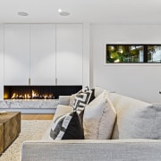 The living room with custom indoor steel-backed fireplace 