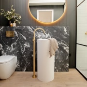 A freestanding vanity basin is backed by a 