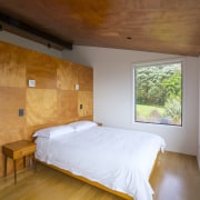 South-facing master bedroom complete with rich-toned timber headboard. 