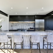 The centrally located island features book matched marble 