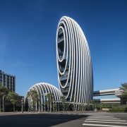 The building's egg-like appeal has a symbolic implication.  architecture, building, city, commercial building, corporate headquarters, daytime, headquarters, landmark, metropolis, metropolitan area, sky, skyscraper, tower, tower block, urban area, blue