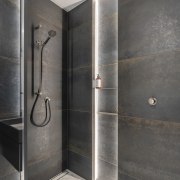 The lit shower niche echoes the display shelving 