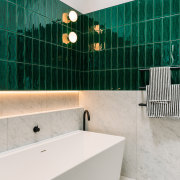 Vibrant green tiles contrast the large format stone-look 