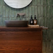 The walnut vanity is underlit to dramatic effect. 