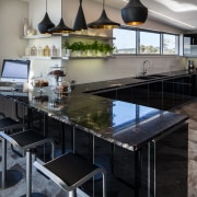 The large seating area acts as a servery countertop, interior design, kitchen, real estate, gray, black