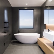 ​​​​​​​For this bathroom by designer Davinia Sutton, shapes architecture, bathroom, floor, flooring, interior design, tile, gray, black, Freestanding bath, Davinia Sutton