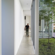 ​​​​​​​A hallway connects the main living areas with architecture, building, daylighting, door, facade, floor, glass, house, interior design, room, window, gray