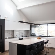 ​​​​​​​A veined marble-look engineered splashback adds interest to white