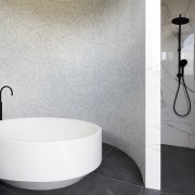 The twinkling mosaic wall behind this master bathroom's gray, white