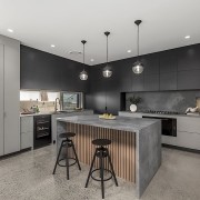 Contemporary kitchen with waterfall benchtop adjacent to outdoor 
