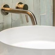 Table top basin meets wall-mounted, bronze-look tapware. 