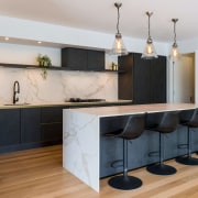 A slender waterfall benchtop adds to the kitchen's 