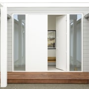 A pergola and wood front door opening to 