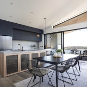 Kitchen with black cabinetry and island with mesh-fronted 