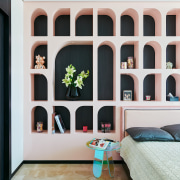 The pink shelving unit behind the bed in 