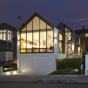 The glazed gable form of the street frontage architecture, building, estate, facade, home, house, interior design, lighting, night, property, real estate, residential area, sky, tree, window, black, blue