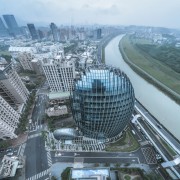 The building's egg-like shape implies it is an aerial photography, architecture, bird's-eye view, building, city, cityscape, commercial building, corporate headquarters, daytime, downtown, freeway, headquarters, human settlement, landmark, landscape, metropolis, metropolitan area, mixed-use, real estate, sky, skyline, skyscraper, tower, tower block, urban area, urban design, world, gray, teal