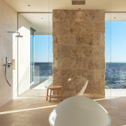 Stone blocks and glass semi-enclose the understated shower 