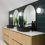 Black concrete basins, large arched mirrors, and elegant 