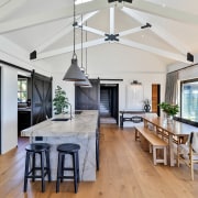 The gabled ceiling with exposed beams connects with 