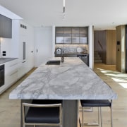 A veined white stone benchtop is the kitchen's 