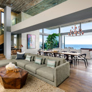 The living level is set back considerably to apartment, architecture, building, ceiling, coffee table, couch, estate, floor, flooring, furniture, hardwood, home, house, interior design, laminate flooring, living room, loft, property, real estate, roof, room, table, wall, wood, wood flooring, gray