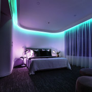 Considering the apartment was originally built in the architecture, ceiling, hotel, interior design, light, lighting, purple, room, suite, wall, black, blue