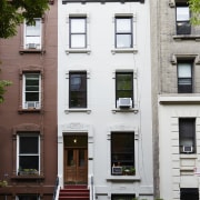 Outside, the home blends into its neighbours - apartment, architecture, building, door, facade, home, house, neighbourhood, property, real estate, residential area, window, white