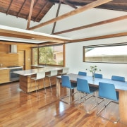An exposed ceiling with gables opens up the architecture, beam, ceiling, daylighting, dining room, floor, flooring, hardwood, house, interior design, loft, real estate, table, wood, wood flooring, white, orange