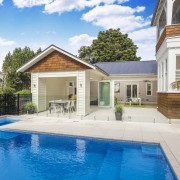 The swimming pool features a connected spa pool backyard, cottage, estate, facade, home, house, property, real estate, residential area, swimming pool, villa, white