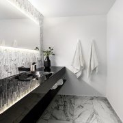 The illuminated mirror is the stand-out element in apartment, architecture, bathroom, black and white, ceiling, daylighting, design, floor, home, house, interior design, monochrome, monochrome photography, product design, room, tap, white, gray