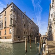 Located in the centre of the city, the building, canal, city, facade, historic site, medieval architecture, sky, tourist attraction, town, waterway, orange