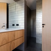 The bathroom is spacious and features contrasting elements architecture, bathroom, ceiling, floor, flooring, interior design, room, sink, tile, wall, wood flooring, gray, black
