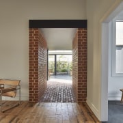 The brick 'tunnel' connects the new and the door, floor, flooring, home, house, interior design, real estate, window, window covering, window treatment, wood, gray