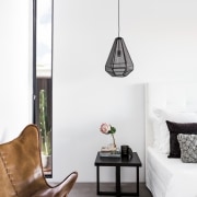 A hanging pendant light sits over this end furniture, home, interior design, lamp, light fixture, lighting, lighting accessory, living room, product design, table, wall, white