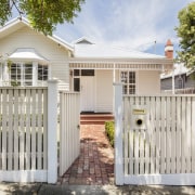 From the street, nothing appears to have changed cottage, estate, facade, fence, gate, home, home fencing, house, outdoor structure, picket fence, property, real estate, residential area, siding, gray