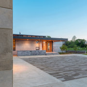 The driveway pattern connects the garage to the architecture, estate, facade, home, house, real estate, residential area, road surface, roof, sky, wall, gray