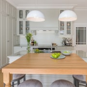 Two hanging lights draw the eye - Two countertop, floor, home, interior design, kitchen, real estate, room, table, wood flooring, gray