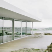 A spacious deck wraps around the sea-facing side architecture, daylighting, glass, house, interior design, shade, window, white, gray