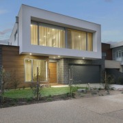 The block-like nature of the home results in architecture, building, elevation, facade, home, house, property, real estate, residential area, siding, window, gray