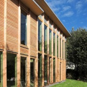 A closer view of the wood exterior - architecture, column, facade, grass, house, real estate, siding, structure, window, orange