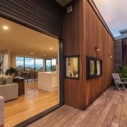 The living area opens out onto the deck deck, estate, hardwood, home, house, interior design, property, real estate, roof, window, wood, brown