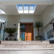 This home features a classic wood door with architecture, daylighting, door, estate, facade, home, house, property, real estate, window, gray