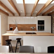 Wood accents tie this glossy white kitchen together architecture, ceiling, countertop, interior design, kitchen, table, gray, brown