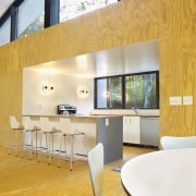 The kitchen sits in a nook off to architecture, ceiling, chair, floor, flooring, furniture, house, interior design, loft, table, wall, orange, white