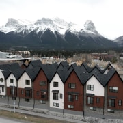 The buildings add to the character of the alps, building, city, home, house, mountain, mountain range, neighbourhood, real estate, residential area, roof, sky, snow, suburb, town, winter, white, black, gray