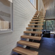 White brick meets dark tile in this hallway architecture, daylighting, floor, flooring, handrail, hardwood, home, house, interior design, laminate flooring, stairs, wall, wood, wood flooring, gray